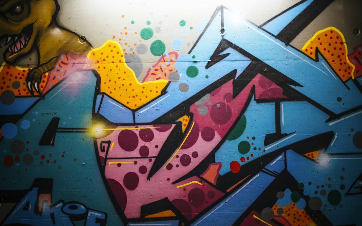 Graffiti colorat cu litere mari pe un perete