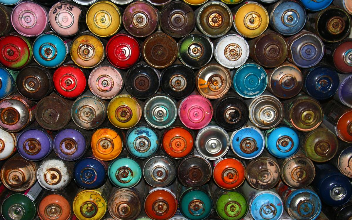 Capace colorate ale unor tuburi de spray, văzute de sus