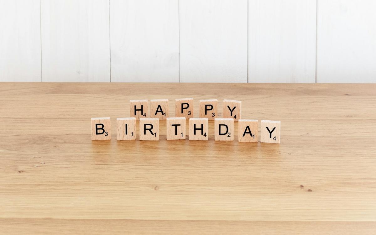 Litere din lemn care formează mesajul HAPPY BIRTHDAY, pe o masă