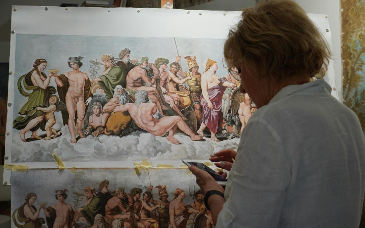 Restauratoare care lucrează la o pictură murală mare