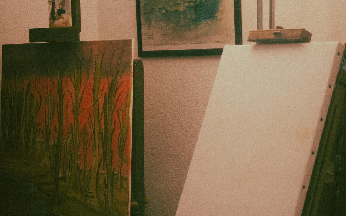 Șevalete cu pânze în lumina caldă a unui atelier